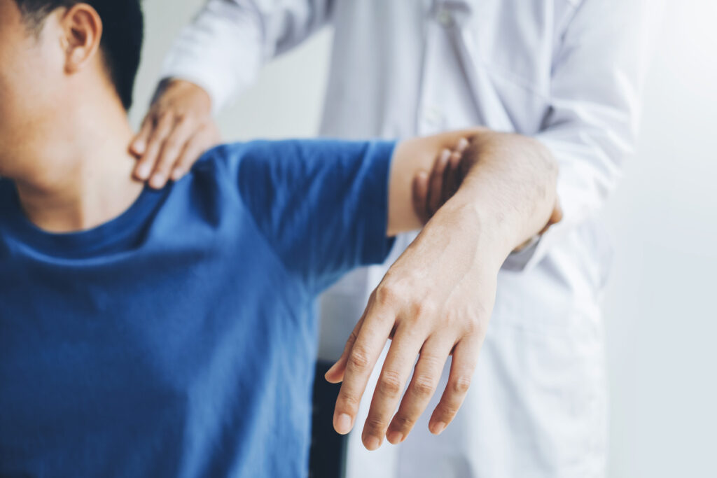 physician helping man after shoulder injury